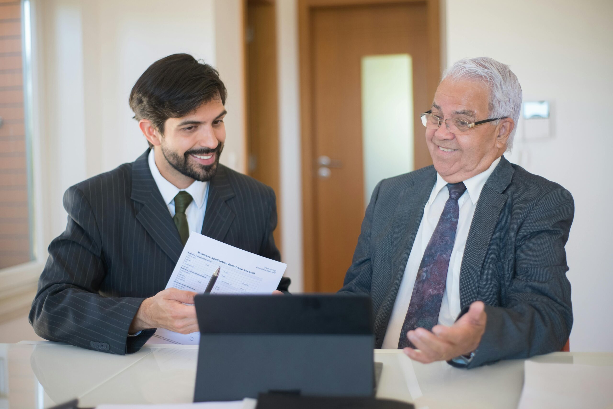 Two businessmen discussing a real estate deal in a modern office setting.